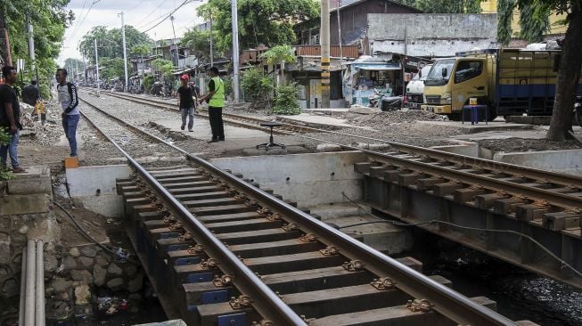 Perlintasan kereta api tanpa pintu dan tanda bahaya di kawasan Bandengan, Jakarta, Jumat (26/1). 