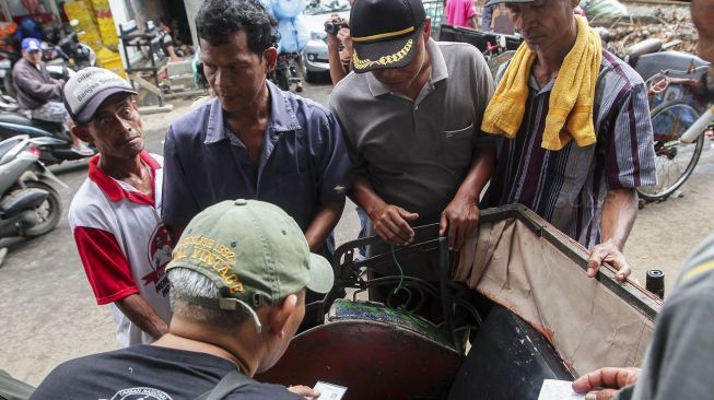 Sejumlah tukang becak melakukan pendataan identitas kepada petugas Kelurahan di kawasan kolong flyover Bandengan, Jakarta, Sabtu (27/1).