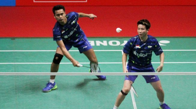 Pasangan ganda campuran Indonesia Tontowi Ahmad/Liliyana Natsir berusaha mengembalikan shuttlecock ke arah ganda campuran Cina, Zheng Siwei/Huang Yaqiong, dalam final bulutangkis Indonesia Masters 2018 di Istora Senayan, Jakarta, Minggu, (28/1). [suara.com/Oke Atmaja]