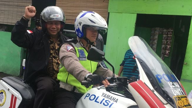 Ketua Badan Pengawas Pemilu Abhan naik sepeda motor ke kantor beberapa partai politik di Jakarta.(suara.com/Erick Tanjung)