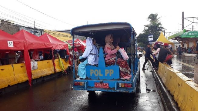 Satpol PP memberikan tumpangan ke warga yang kesulitan mendapatkan angkutan umum. (suara.com/Welly Hidayat)