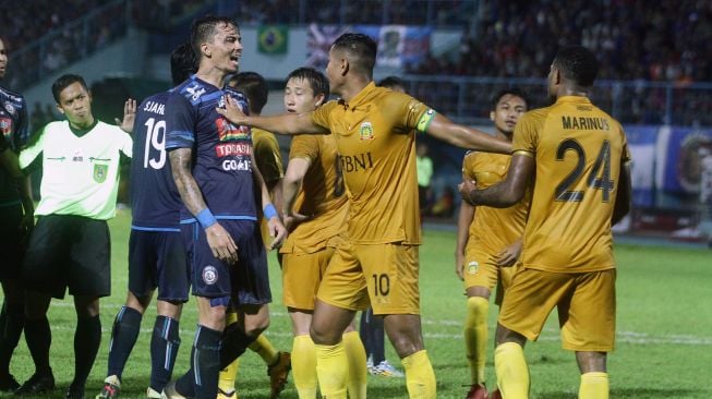 Pemain Bhayangkara FC, Jajang Mulyana (tengah) berusaha melerai rekannya Marinus Mariyanto (kanan) yang bersitegang dengan pemain Arema FC, Rodrigo Ost Dos Santos (kiri). ANTARA FOTO/Ari Bowo Sucipto