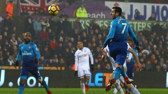 Gelandang Arsenal Henrikh Mkhitaryan menanduk bola di depan gawang Swansea City [AFP]