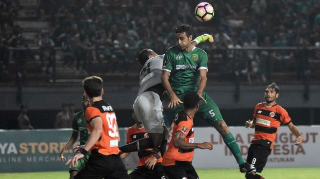 Kiper Perseru Serui Annas Fitranto (kiri) menepis bola dari pemain Persebaya Surabaya Otavio Dutra (kanan) dalam lanjutan grup C Piala Presiden 2018 di Stadion Gelora Bung Tomo. ANTARA FOTO/M Risyal Hidayat.