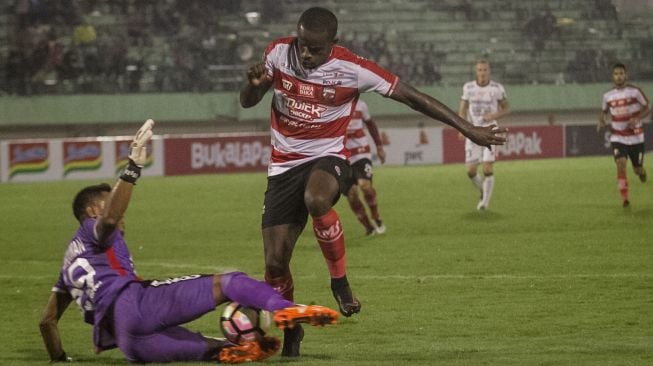 Pemain Madura United Greg Nwokolo dan kiper Bali United Wawan Hendrawan. (Antara)