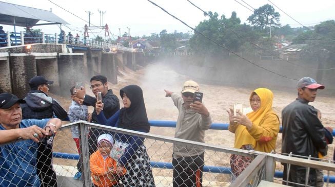 Warga berada di sekitar Bendungan Katulampa di Kota Bogor, Jawa Barat, Senin (5/2). 