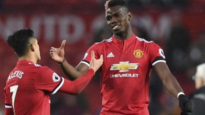 Alexis Sanchez dan Paul Pogba bersalaman usai MU menang 2-0 atas Huddersfield Town di Old Trafford, Sabtu (3/2/2018). [AFP/Paul Ellis]