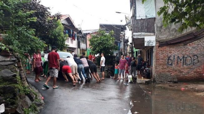 Warga Bidaracina, Jatinegara, Jakarta Timur, tengah mempersiapkan diri menyambut banjir kiriman dari Bendungan Katulampa, Bogor Jawa Barat, Senin (5/2/2018) sore. [Suara.com/Wely Hidayat]