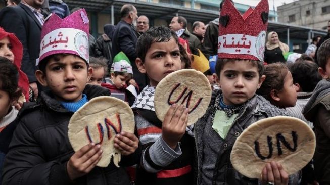 Puluhan bocah Palestina berdemo di Jalur Gaza meminta dunia internasional campur tangan menghentikan blokade Israel, Minggu (28/1/2018). [AFP/Said Khatib]