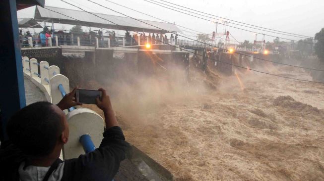 Warga berada di sekitar Bendungan Katulampa di Kota Bogor, Jawa Barat, Senin (5/2). 