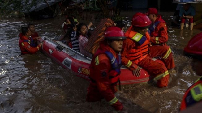 Petugas Damkar melakukan evakuasi dengan perahu karet terhadap korban banjir di kawasan Pejaten Timur, Pasar Minggu, Jakarta, Senin (5/2). 