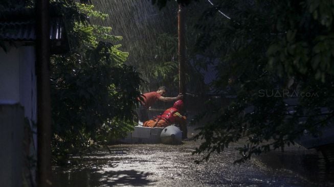 Petugas Damkar melakukan evakuasi dengan perahu karet terhadap korban banjir di kawasan Pejaten Timur, Pasar Minggu, Jakarta, Senin (5/2). 