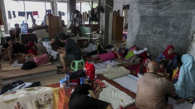 Para pegungsi korban banjir menempati bangunan gedung setengah jadi di lokasi sebuah kampus di kawasan Rawajati, Cililitan, Jakarta, Selasa (6/2).