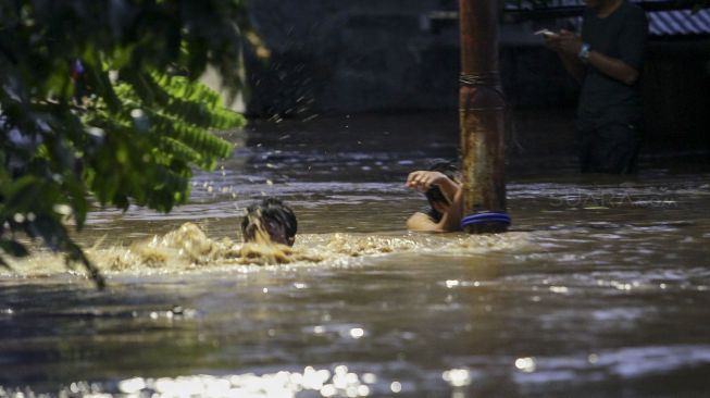 Petugas Damkar melakukan evakuasi dengan perahu karet terhadap korban banjir di kawasan Pejaten Timur, Pasar Minggu, Jakarta, Senin (5/2). 