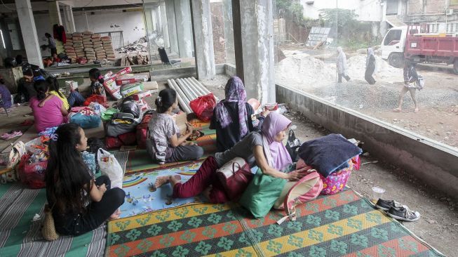 Para pegungsi korban banjir menempati bangunan gedung setengah jadi di lokasi sebuah kampus di kawasan Rawajati, Cililitan, Jakarta, Selasa (6/2).