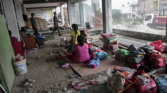 Para pegungsi korban banjir menempati bangunan gedung setengah jadi di lokasi sebuah kampus di kawasan Rawajati, Cililitan, Jakarta, Selasa (6/2).