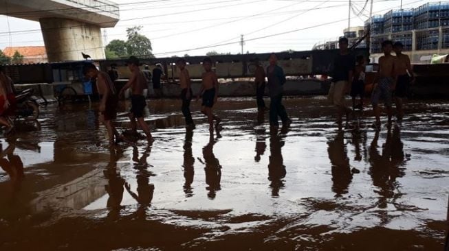 Bermain di Tengah Lumpur, Keceriaan Anak Jakarta Usai Banjir