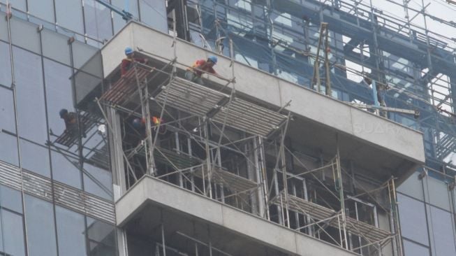 Sejumlah pekerja menyelesaikan proyek pembangunan gedung di kawasan Kuningan, Jakarta, Rabu (7/2).