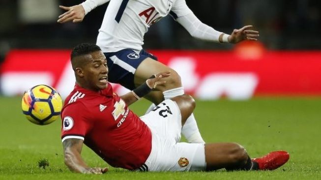 Pemain MU Antonio Valencia menghentikan laju pemain Tottenham Hotspur [AFP]