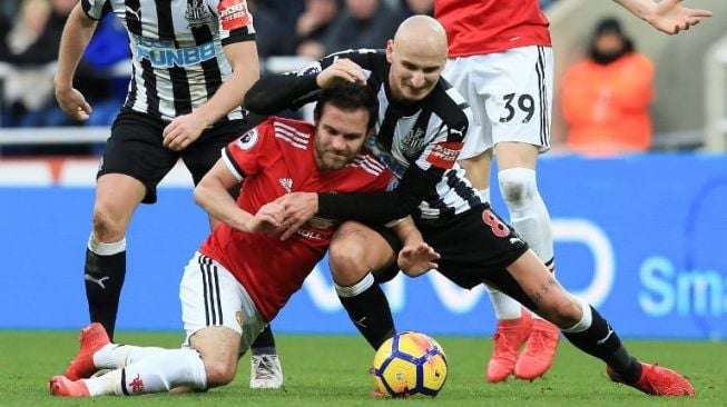 Pemain MU Juan Mata berebut bola dengan pemain Newcastle United [AFP]