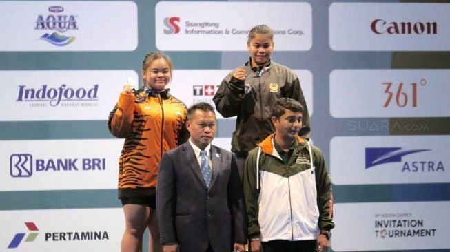 Melinda Gusti berdiri di podium juara usai memenangi kelas 75 kg putri test event Asian Games 2018 cabang angkat besi di JIExpo Kemayoran, Jakarta Pusat, Selasa (12/2). [Suara.com/Dendi Afriyan]