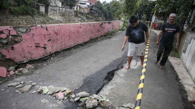 Akibat abrasi pondasi jalan yang tergerus banjir beberapa waktu lalu.