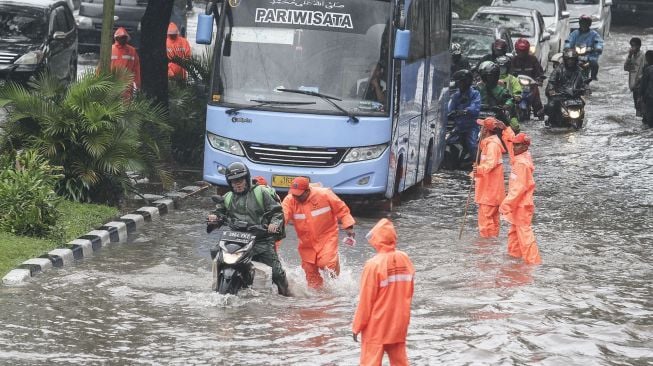 Sejumlah kendaraan tampak melintasi genangan air banjir di Cempaka Putih, Jakarta, Kamis (15/2/2018). [Suara.com/Kurniawan Mas'ud]