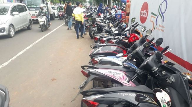 Sejumlah kendaraan roda dua yang terparkir di sisi Jalan Raya Pintu Tiga, area cabang panahan, kawasan Gelora Bung Karno tampak roboh, Sabtu (17/2/2018). (suara.com/Welly Hidayat)