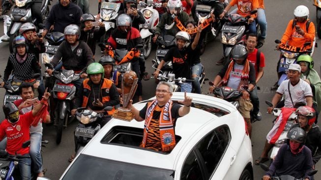 Ribuan suporter Persija Jakarta, Jakmania, berkonvoi mengarak rombongan Persija usai menjuarai Piala Presiden di kawasan Bundaran Hotel Indonesia, Jakarta, Minggu (18/2/2018). Persija menjuarai Piala Presiden usai mengalahkan Bali United dengan skor 3-0 pada sabtu (17/2/2018) [Suara.com/Oke Atmaja] 

