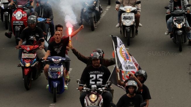 Ribuan suporter Persija Jakarta, Jakmania, berkonvoi mengarak rombongan Persija usai menjuarai Piala Presiden di kawasan Bundaran Hotel Indonesia, Jakarta, Minggu (18/2/2018). Persija menjuarai Piala Presiden usai mengalahkan Bali United dengan skor 3-0 pada sabtu (17/2/2018) [Suara.com/Oke Atmaja] 

