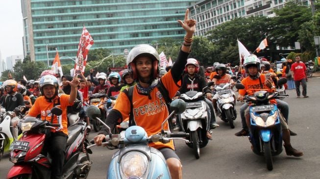 Ribuan suporter Persija Jakarta, Jakmania, berkonvoi mengarak rombongan Persija usai menjuarai Piala Presiden di kawasan Bundaran Hotel Indonesia, Jakarta, Minggu (18/2/2018). Persija menjuarai Piala Presiden usai mengalahkan Bali United dengan skor 3-0 pada sabtu (17/2/2018) [Suara.com/Oke Atmaja] 