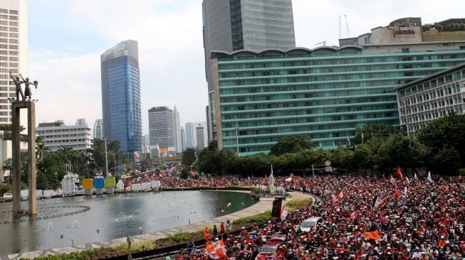 Ribuan suporter Persija Jakarta, Jakmania, berkonvoi mengarak rombongan Persija usai menjuarai Piala Presiden di kawasan Bundaran Hotel Indonesia, Jakarta, Minggu (18/2/2018). Persija menjuarai Piala Presiden usai mengalahkan Bali United dengan skor 3-0 pada sabtu (17/2/2018) [Suara.com/Oke Atmaja] 

