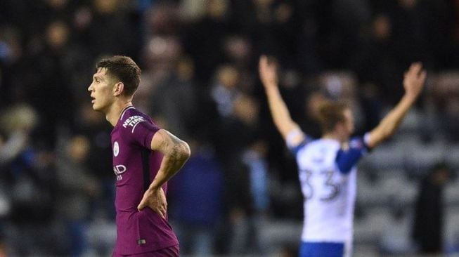 Bek Manchester City, John Stones, terdiam setelah timnya dipermalukan Wigan Athletic dengan skor 1-0 di putaran lima Piala FA, Senin (19/2) malam. [AFP/Oli Scarff]