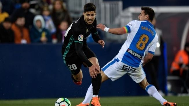 Pemain Real Madrid Asensio (kiri) melewati hadangan pemain Leganes Gabriel Apelt. OSCAR DEL POZO / AFP