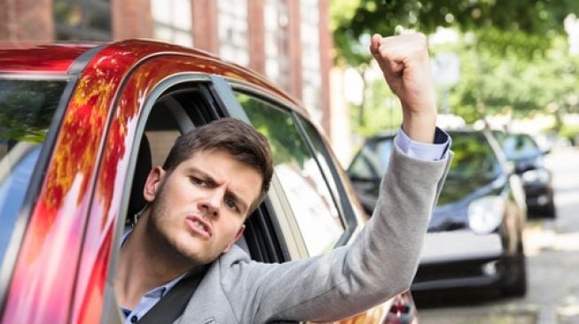 Ilustrasi seorang lelaku mengepalkan tangannya karena marah saat berkendara. [Shutterstock]