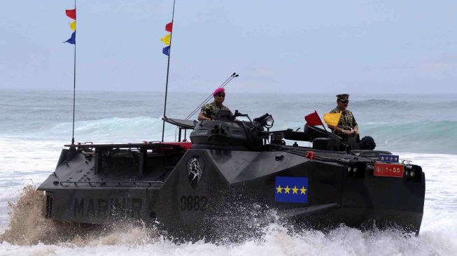 Panglima TNI Marsekal TNI Hadi Tjahjanto (kanan) didampingi Komandan Korps Marinir Mayjen TNI (Mar) Bambang Suswantono (kiri) berada di atas kendaraan tempur Landing Vehicle Tank-7 (LVT-7) disela-sela Pengangkatan Warga Kehormatan Marinir di pantai Nganteb, Kab. Malang, Jawa Timur, Kamis (22/2). 