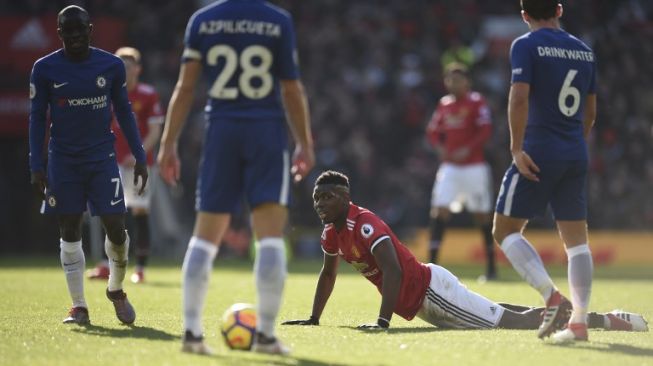 Pemain MU Paul Pogba terjatuh usai mendapat tekel dari pemain Chelsea N'Golo Kante [AFP]