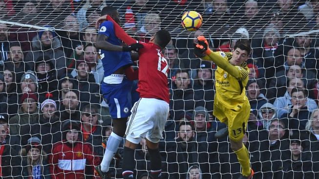 Penjaga gawang Chelsea Thibaut Courtois meninju bola [AFP]