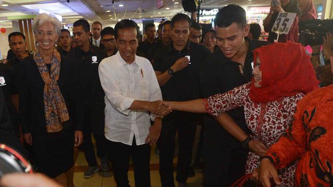 Presiden Joko Widodo (kedua kiri) bersama Direktur Pelaksana Dana Moneter Internasional (IMF) Christine Lagarde (kiri) menyalami warga ketika melakukan blusukan ke Pasar Tanah Abang Jakarta, Senin (26/2). 