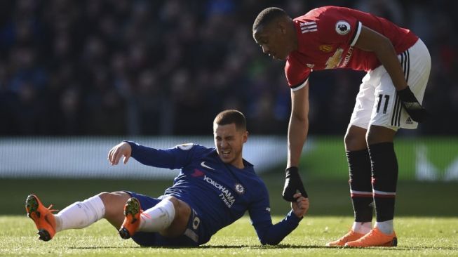 Pemain MU Anthony Martial (kanan) membantu pemain Chelsea Eden Hazard untuk berdiri [AFP]