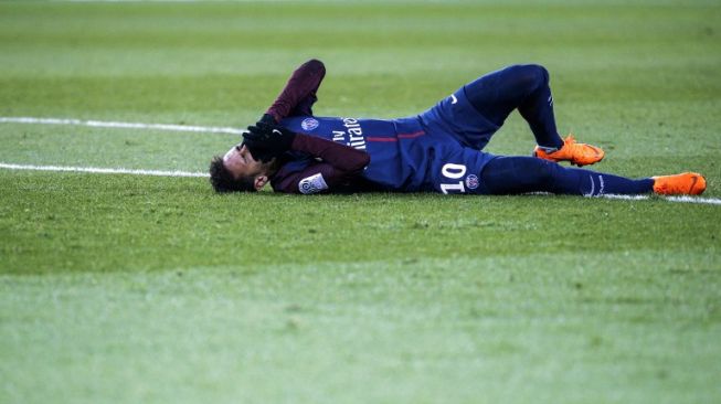 Pemain PSG Neymar terbaring kesakitan usai mendapat tekel keras dari pemain Marseille, Bouna Sarr [AFP]