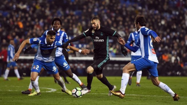 Pemain Madrid Karim Benzema mencoba melewati dua pemain Espanyol [AFP]