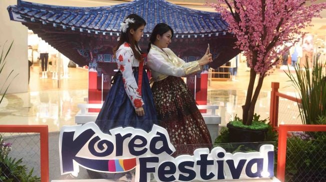 Pengunjung berswafoto dengan latar rumah khas Korea saat Korea Festival di Surabaya, Jawa Timur, Jumat (2/3). 