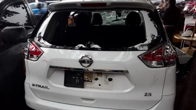 Kondisi Mobil Nissan X-Trail yang kini terparkir di Polres Metro Jakarta Pusat sebagai alat bukti setelah diamuk para driver ojek online (ojol) di terowongan underpass Johar Baru, Pasar Senen, Jakarta Pusat, Rabu (28/2/2018) malam. [Suara.com/Welly Hidayat]