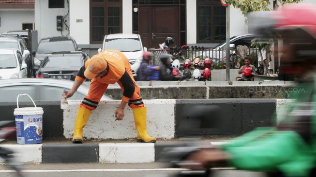 Petugas Penanganan Prasarana dan Sarana Umum (PPSU) DKI Jakarta mengecat trotoar pembatas jalan di Jalan Jatinegara, Jakarta, Jumat (2/3).