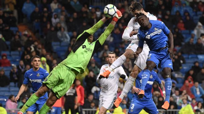 Striker Real Madrid, Cristiano Ronaldo, menyundul bola yang berbuah gol keduanya dalam pertandingan melawan Getafe dalam lanjutan La Liga di Santiago Bernabeu, Sabtu (3/3/2018). [AFP/Pierre-Philippe Marcou]