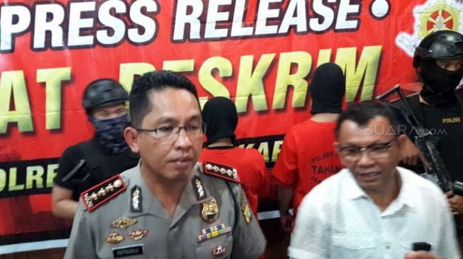 Kapolres Metro Jakarta Pusat Kombes Roma Hutajulu (kiri) saat mengungkap kasus perusakan dan penganiayaan terhadap penumpang mobil Nissan X-Trail yang dilakukan dua tersangka driver ojek onlien (ojol) di Polres Metro Jakarta Pusat, Senin (5/3/2018). [Suara.com/Welly Hidayat]