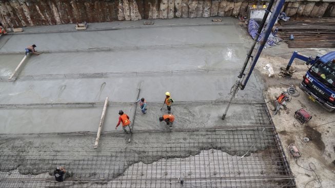 Pekerja melakukan pengecoran proyek underpass Kuningan-Mampang, di Jalan HR Rasuna Said, Jakarta, Selasa (6/3/2018) [Suara.com/Kurniawan Mas'ud]