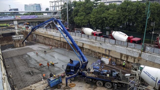 Pekerja melakukan pengecoran proyek underpass Kuningan-Mampang, di Jalan HR Rasuna Said, Jakarta, Selasa (6/3/2018) [Suara.com/Kurniawan Mas'ud]