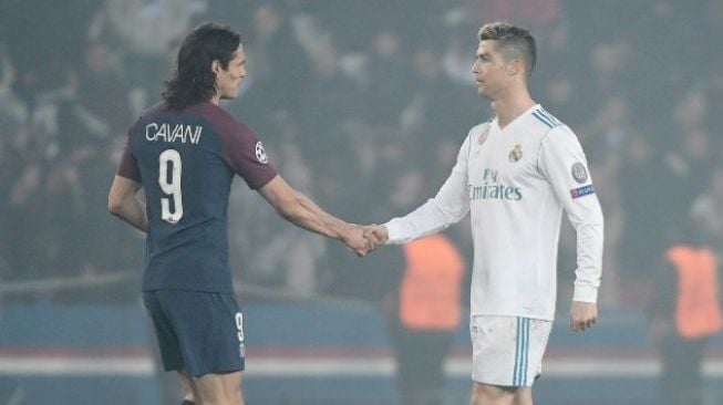 Bintang Real Madrid Cristiano Ronaldo (kanan) berjabat tangan dengan striker Paris Saint-Germain Edinson Cavani. CHRISTOPHE SIMON / AFP
